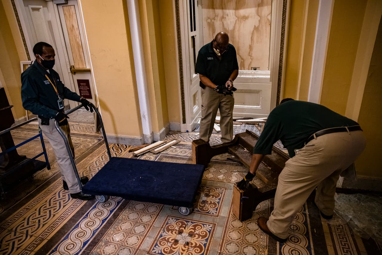 Personal del congreso recogiendo los escobros que dejó la invasión. La policía de Washington DC y el FBI pidió ayuda a los ciudadanos para identificar a los asaltantes.
<br>