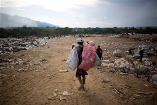 Un hombre carga con bolsas de material reciclable que recogió en un vertedero en Puerto Cabello, el pasado noviembre. Cuando la comida se echa a perder, los militares tratan de deshacerse de ella discretamente, según denuncian algunos empleados del puerto de forma anónima.