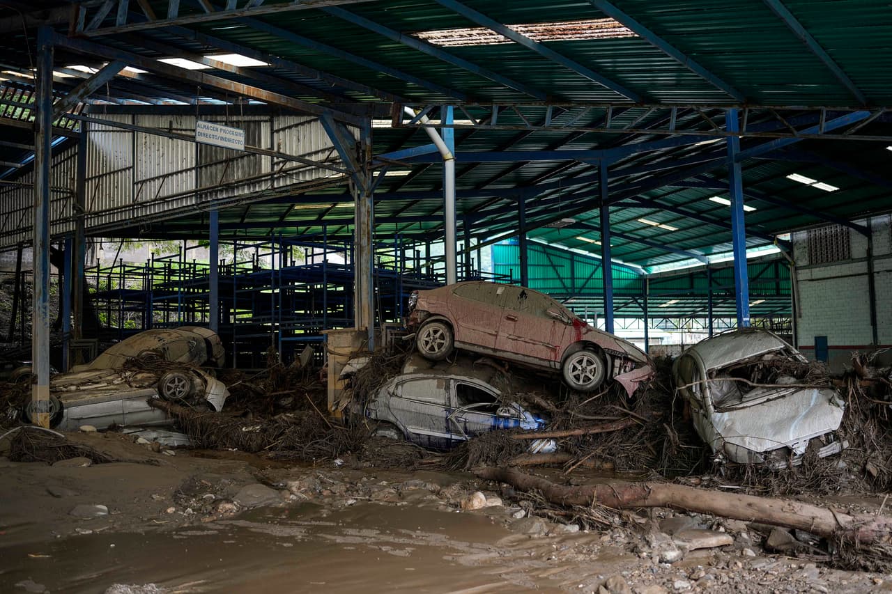 Varios automóviles yacen apliados en un taller luego de que intensas lluvias provocaron inundaciones repentinas y el desbordamiento del río Las Tejerías, este domingo 9 de octubre de 2022, en Las Tejerías, Venezuela.