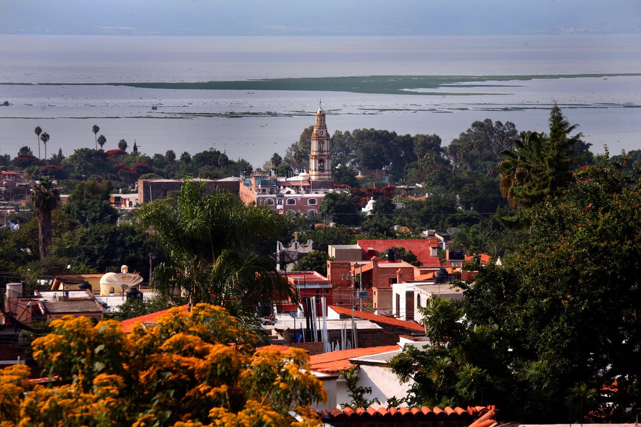 <b>Lago Chapala, entre Michoacán y Jalisco</b>
<br>
<br>Muy cerca de Guadalajara está el lago más grande de México y en su área circundante vive una gran concentración de extranjeros estadounidenses. Según BBC mundo, 
<a href="https://www.bbc.com/mundo/noticias-america-latina-48998509"><u>solo en Ajijic, uno de los pueblos en la costa del lago Chapala, viven alrededor de 14,000</u></a>. Junto a miles de canadienses, se han sentido atraídos a esta zona por el clima y el bajo costo de la vida. También por sus casas de azulejos pintados a mano y sus jardines que florecen durante todo el año. 
<br>
<br>Los pueblos de Ajijic y Chapala son paraísos de artistas, escritores y bohemios. Los extranjeros se reúnen con los lugareños en el enorme mercado al aire libre de Ajijic (en la foto), un gran lugar para comprar tallas, joyas hechas a mano, ropa, flores, frutas, verduras, alimentos cocinados y artículos para el hogar. 
<br>