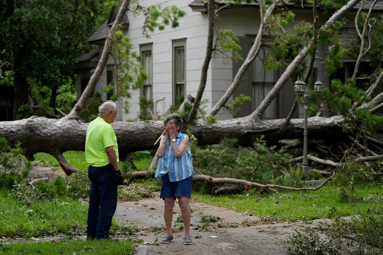 Jackie Jecmenek, a la derecha, habla con el trabajador de la ciudad Bobby Head mientras se encuentra frente a la casa de su vecino en Bay City, Texas. (AP Photo/Eric Gay)