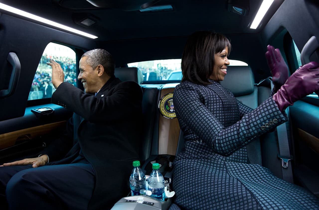 <b>Saludo blindado</b>. Barack y Michelle Obama saludan a la multitud por las ventanas del auto presidencial.