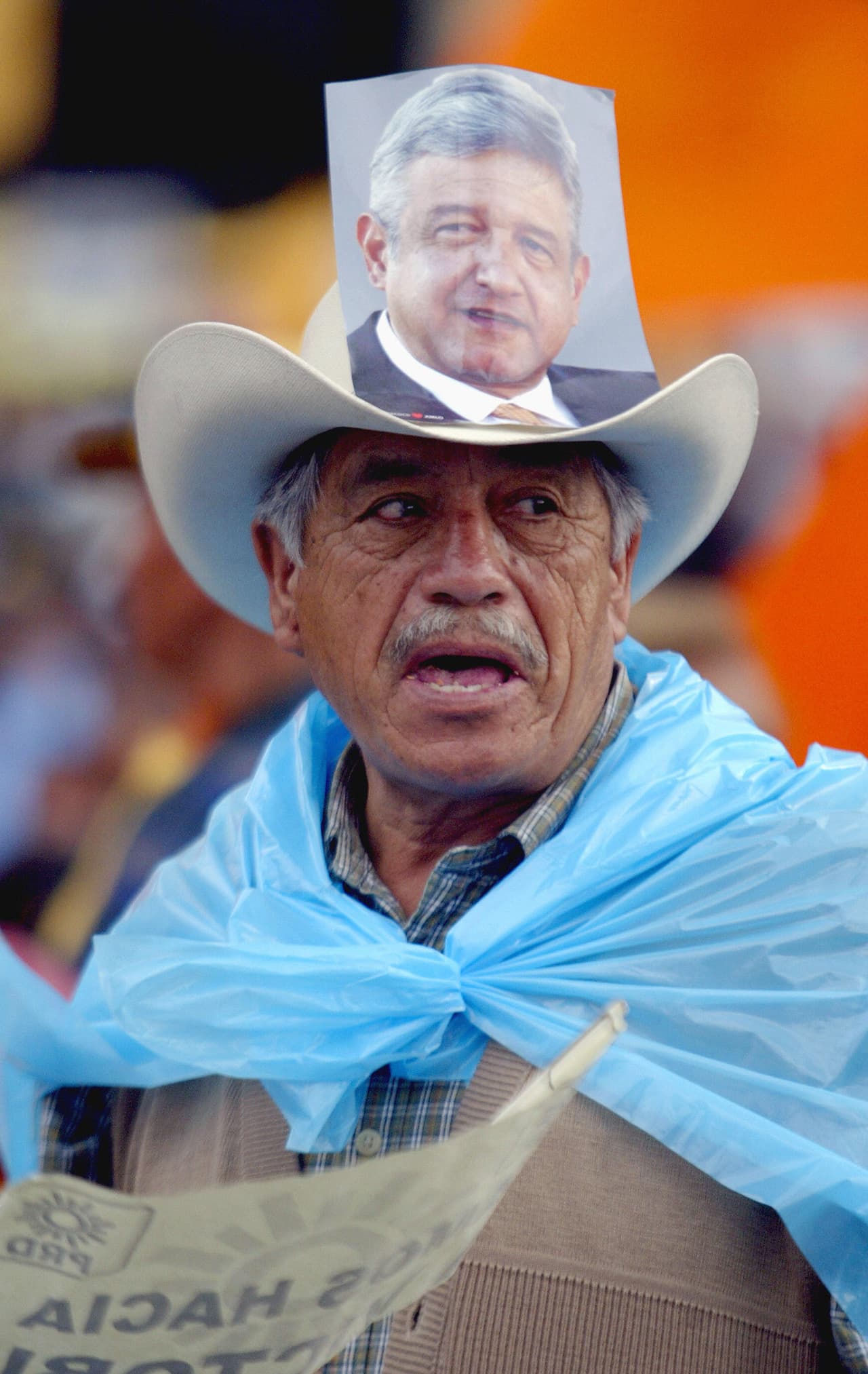 No obtante, en ese entonces la industria que comercializaba la imagen del candidato era un poco más austera, como en esta imagen, donde un simpatizante de AMLO lucía una ifotografía del candidato pegada a su sombrero, en junio de 2006, un mes antes de la contienda electoral, en el Zócalo de la Ciudad de México.