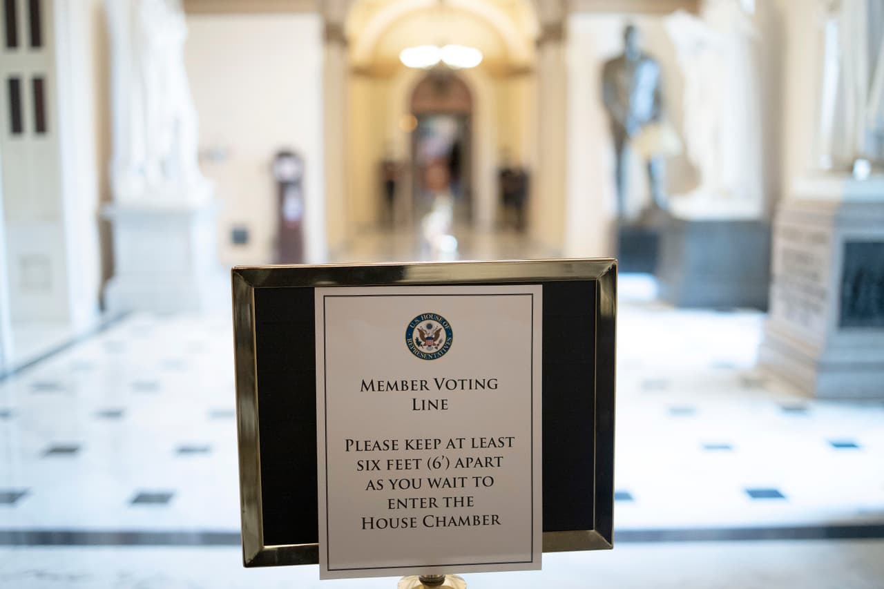 Un cartel que instruye a los congresistas a mantener las normas de distanciamiento social durante la sesión, visto en uno de los pasillos del Capitolio.