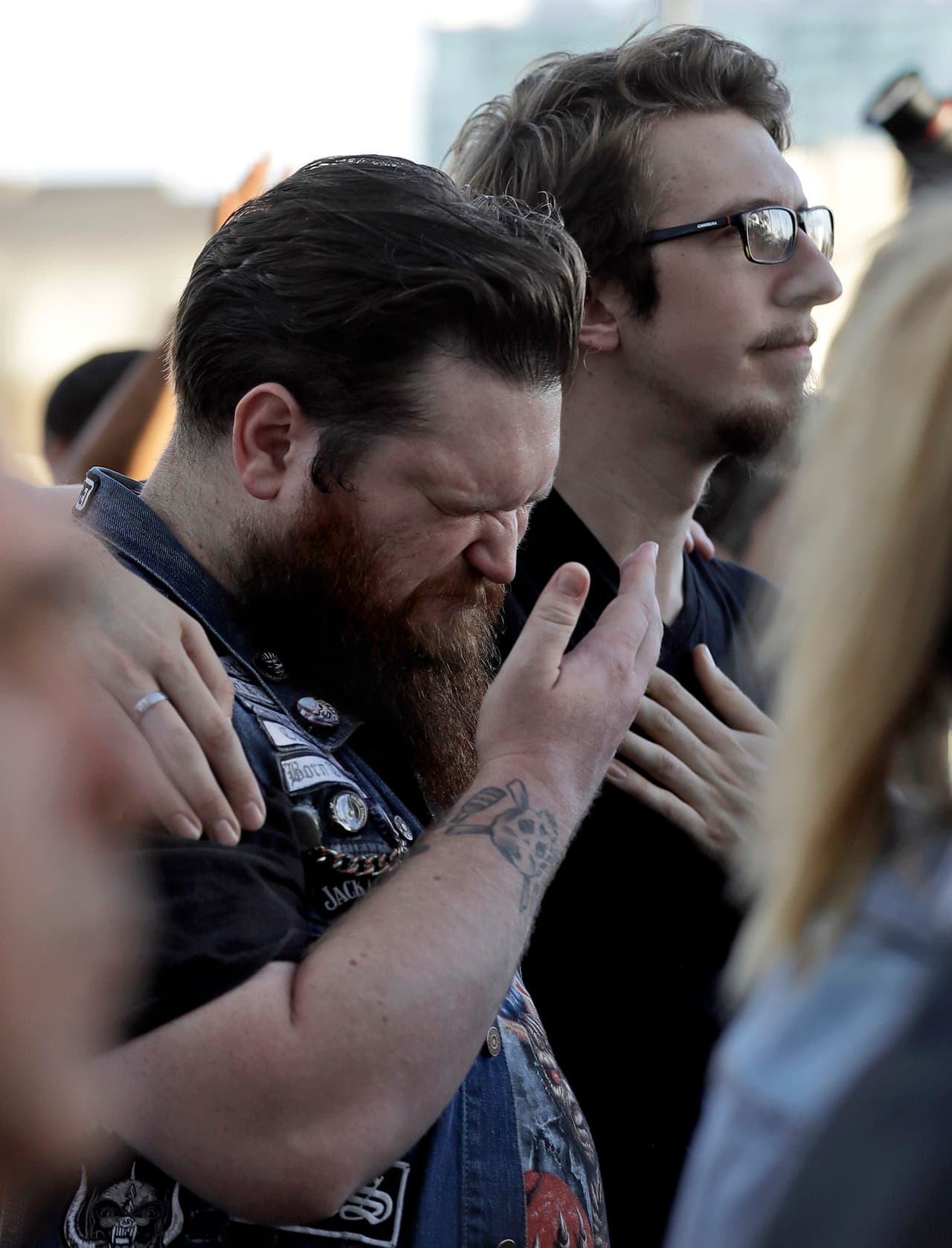 Sean Bolger, un asistente al festival de música country, llora mientras es consolado por un amigo durante una vigilia en el Ayuntamiento de Las Vegas.