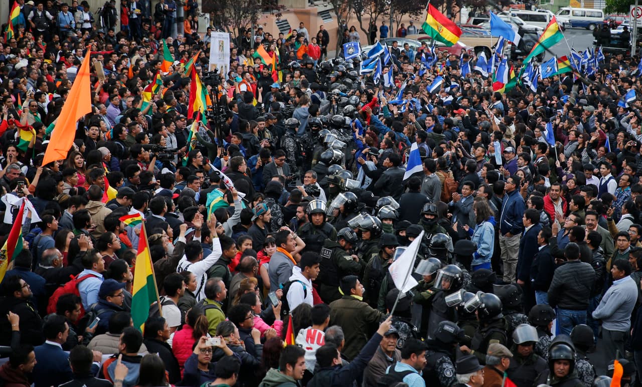 Como Mesa, Morales también ha llamado a sus seguidores a "organizarse para defender la democracia". La movilización de partidarios de ambos candidatos en las calles ha provocado algunos choques. En la imagen, una línea de policías separa a manifestantes afines a ambos contendientes a las afueras del Tribunal Supremo Electoral.