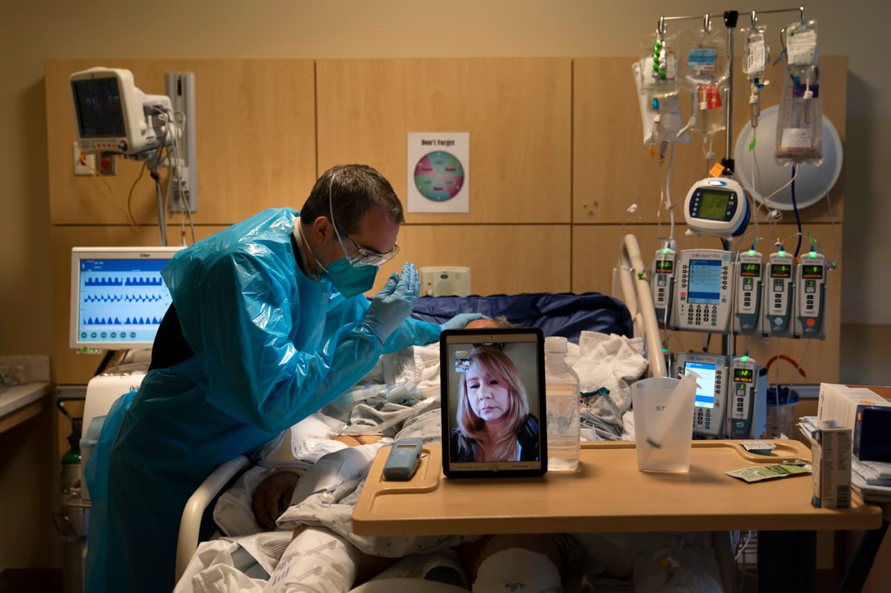 California ordenó que a partir del sábado las personas que no están trabajando en tareas esenciales permanezcan en casa desde las 10 de la noche hasta las cinco de la mañana. En la foto, el capellán del hospital Providence Holy Cross Medical Center reza junto a un enfermo de covid-19 y su hija, presente a través de una videollamada. 19 de noviembre.
<br>
<br> 
<br>