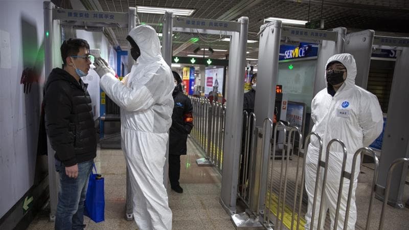 Salud y seguridad: Además del mejoramiento necesario de los sistemas de atención sanitaria, veremos el desarrollo de formas más sofisticadas para identificar quienes son un riesgo de enfermedad y quienes no. En la imagen: Un trabajador toma la temperatura de un pasajero en la entrada de una estación de metro en Beijing.