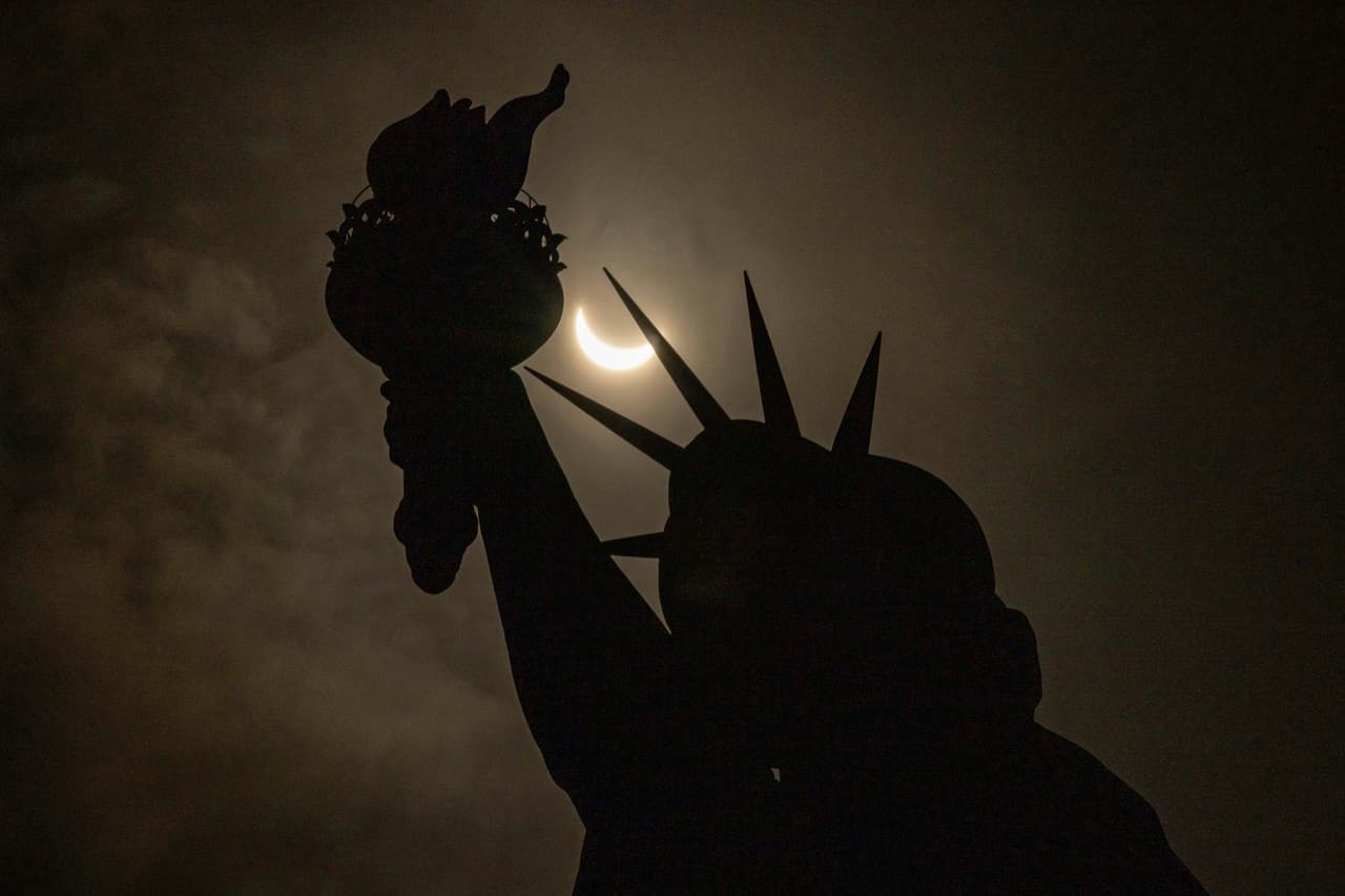 En Nueva York, la Luna se observó parcialmente cubriendo la Estatua de la Libertad durante el eclipse solar en Liberty Island.