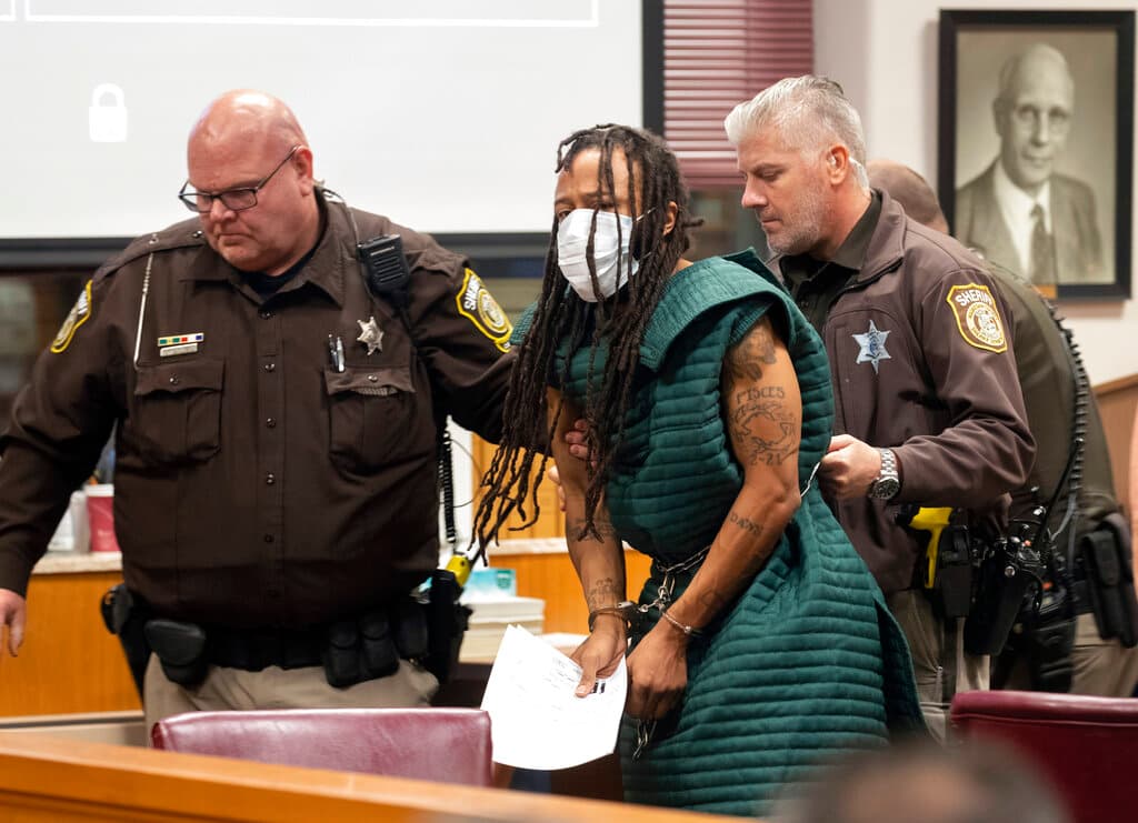 Darrell Brooks es escoltado por dos oficiales al finalizar la audiencia en un juzgado de Waukesha donde le impusieron cinco cargos por asesinato intencional y fijaron una fianza por cinco millones de dólares.