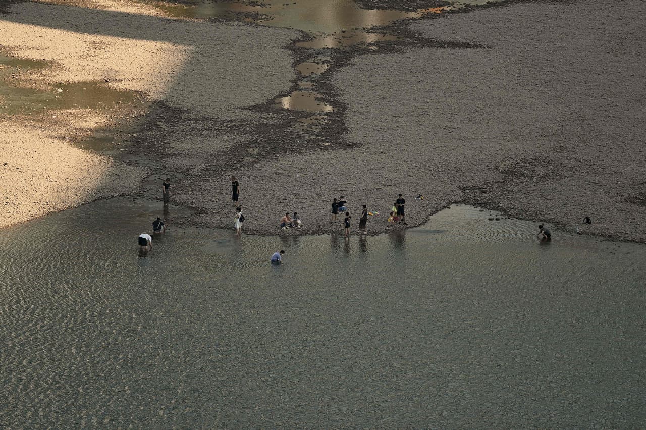 El impacto de la sequía del Yangtze ha sido enorme. En Sichuan, una provincia de 84 millones de habitantes, la energía hidroeléctrica representa alrededor del 80% de la capacidad eléctrica. En la imagen, varias personas se refrescan en el lecho del río Jialing.