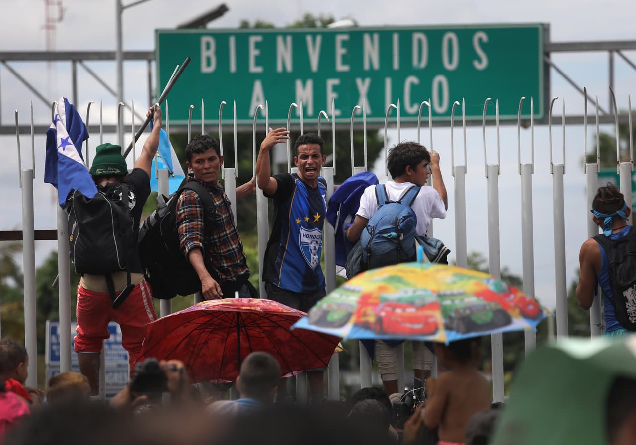 La policía mexicana hizo retroceder a los migrantes en el puente fronterizo con escudos antimotines y gas pimienta, pero la acción represiva no fue capaz de contener el volumen de migrantes.