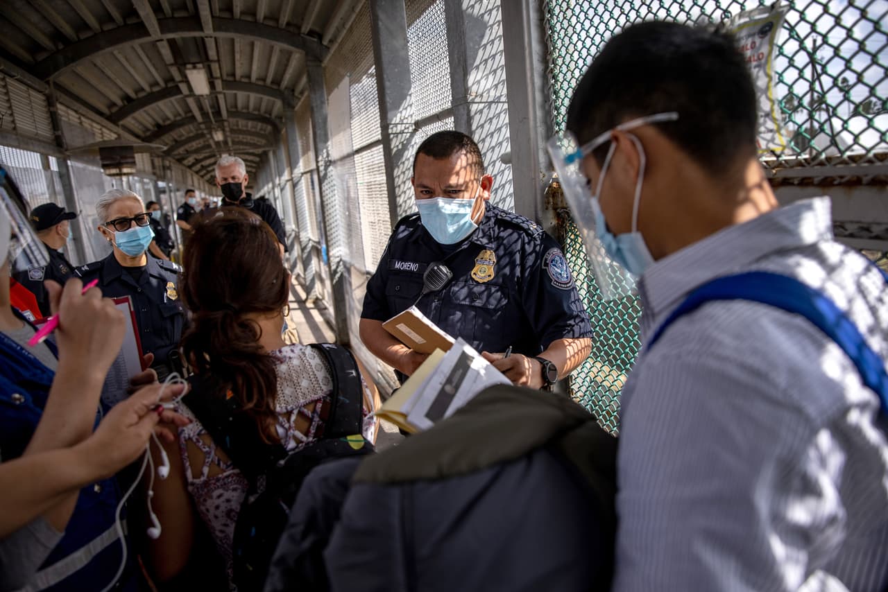 <b>¿Todo en orden? </b>Un oficial de Aduanas y Protección Fronteriza de EEUU habla con inmigrantes en la frontera con México.