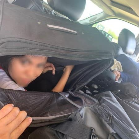 Una mexicana se observa en el interior de una maleta negra, en la parte trasera de una camioneta pick up que trataba de pasar un retén de la Patrulla Fronteriza en la carretera 35, en el norte de Laredo, en Texas. Un perro policía alertó que algo extraño había dentro del vehículo. Al revisar, los agentes federales descubrieron a dos indocumentados de México, cada uno dentro de una maleta grande. El chofer, un ciudadano estadounidense, fue detenido. Esto ocurrió el mediodía del 8 de julio.