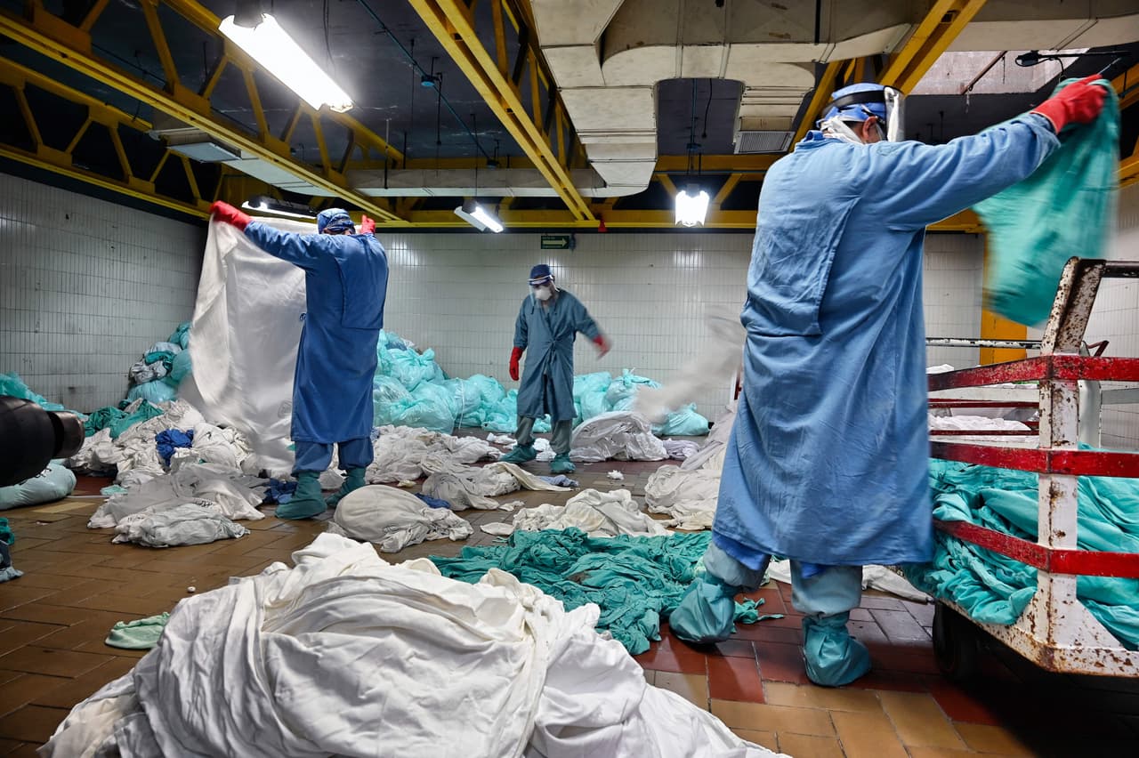 <b>Cuidado en las lavanderías (10 de septiembre).</b> Un grupo de trabajadores manipula la ropa sucia proveniente de la zona covid-19 en la lavandería del Instituto Mexicano del Seguro Social, en la Ciudad de México. Además de los médicos y enfermeras, el personal de limpieza también ha arriesgado su vida en los hospitales de todo el mundo.