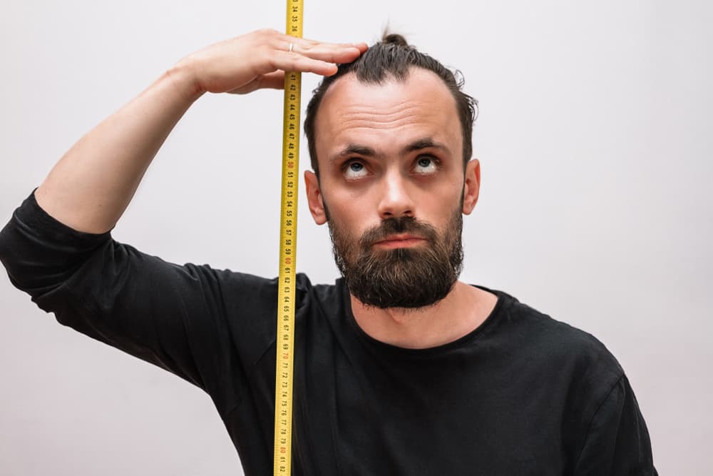Luego calcularás la distancia entre el ombligo y el centro del cráneo, o sea la parte superior del mismo. Colocas una regla sobre la cabeza para lograr un plano horizontal y a partir de ahí vuelves a dejar caer la plomada midiendo hasta el ombligo.
