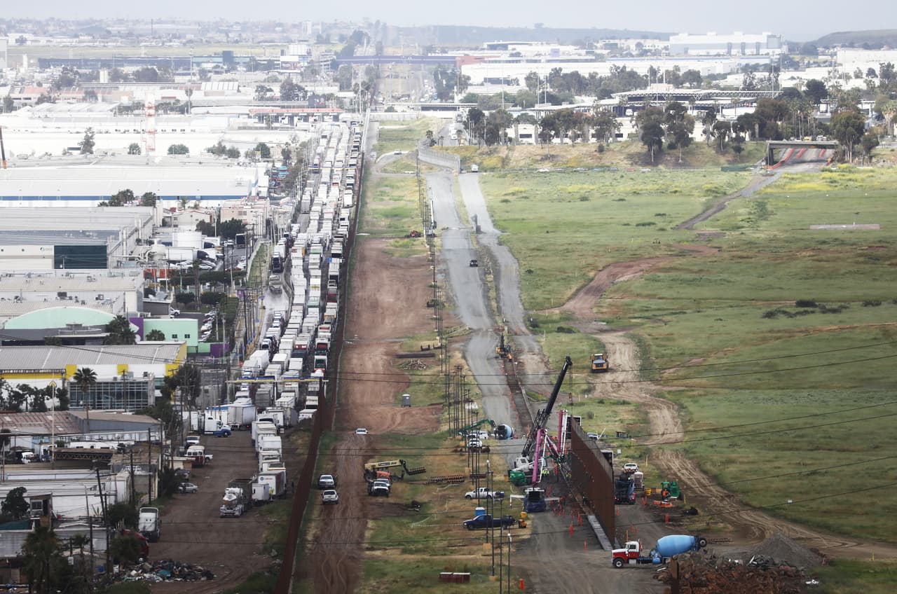 El Departamento de Seguridad Nacional está construyendo 12.5 millas de la barrera fronteriza secundaria en el condado de San Diego, junto a esta construcción la inusual fila de camiones.