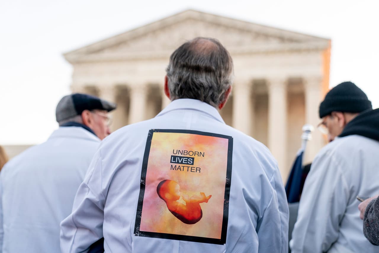 <b>“La vida de los no nacidos importa”</b>, se lee en el cartel que incluye la figura de un feto en la camisa de un manifestante. 
<br>
<br>El juez conservador Clarence Thomas es el único miembro de la corte que ha pedido abiertamente que se anulen los fallos Roe vs. Wade y Planned Parenthood vs. Casey. 
<br>