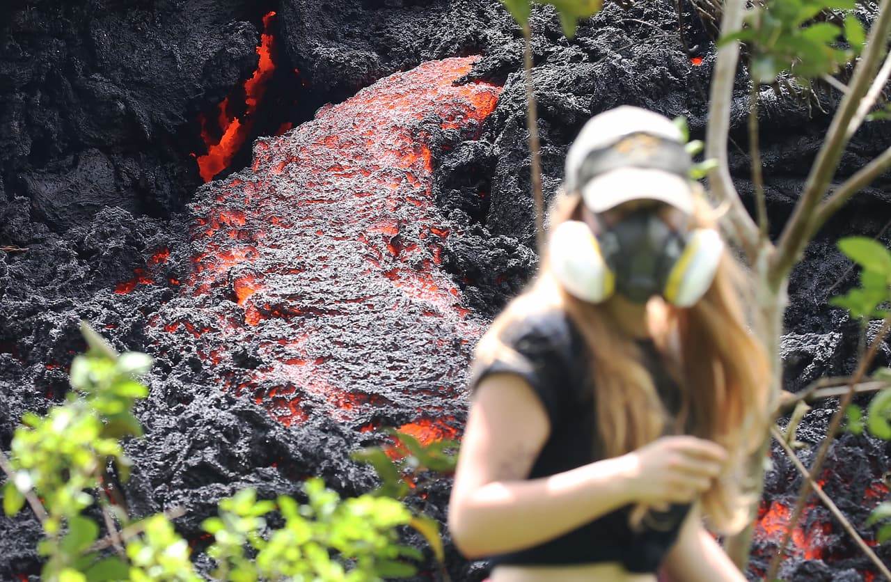 Una residente que se acercó a uno de los flujos de lava incandescente para tomar fotografías, al menos usaba una máscara que la protegía de los gases. La última fisura volcánica se abrió el martes y arrojó lava y gases tóxicos que llevaron la calidad del aire a niveles peligrosos en la comunidad de Lanipuna Gardens.