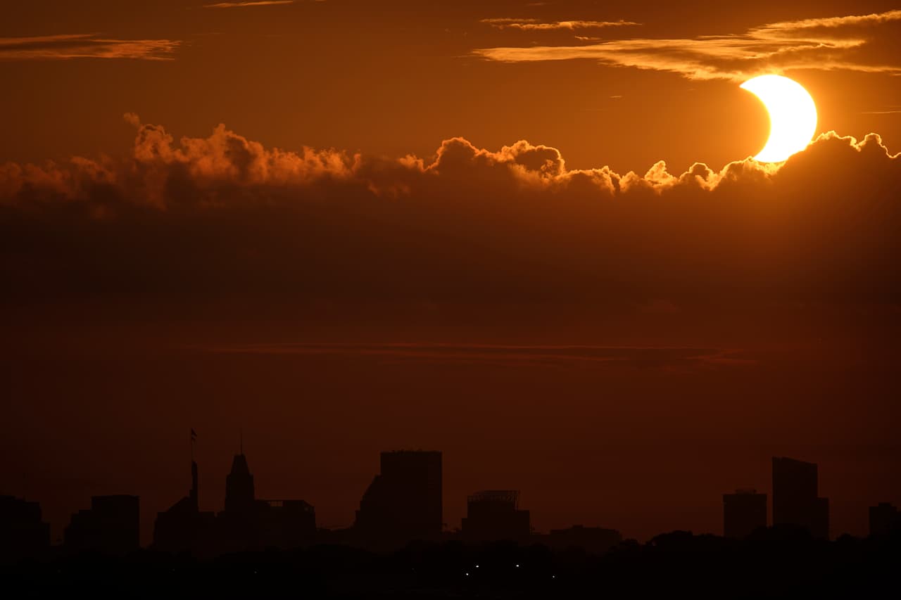 Otra vista desde Maryland en el momento en que la luna comienza a tapar el sol. Los ecplises de sol nunca deben ser vistos directamente sin utilizar protección para los ojos. La exposición directa no está recomendada.