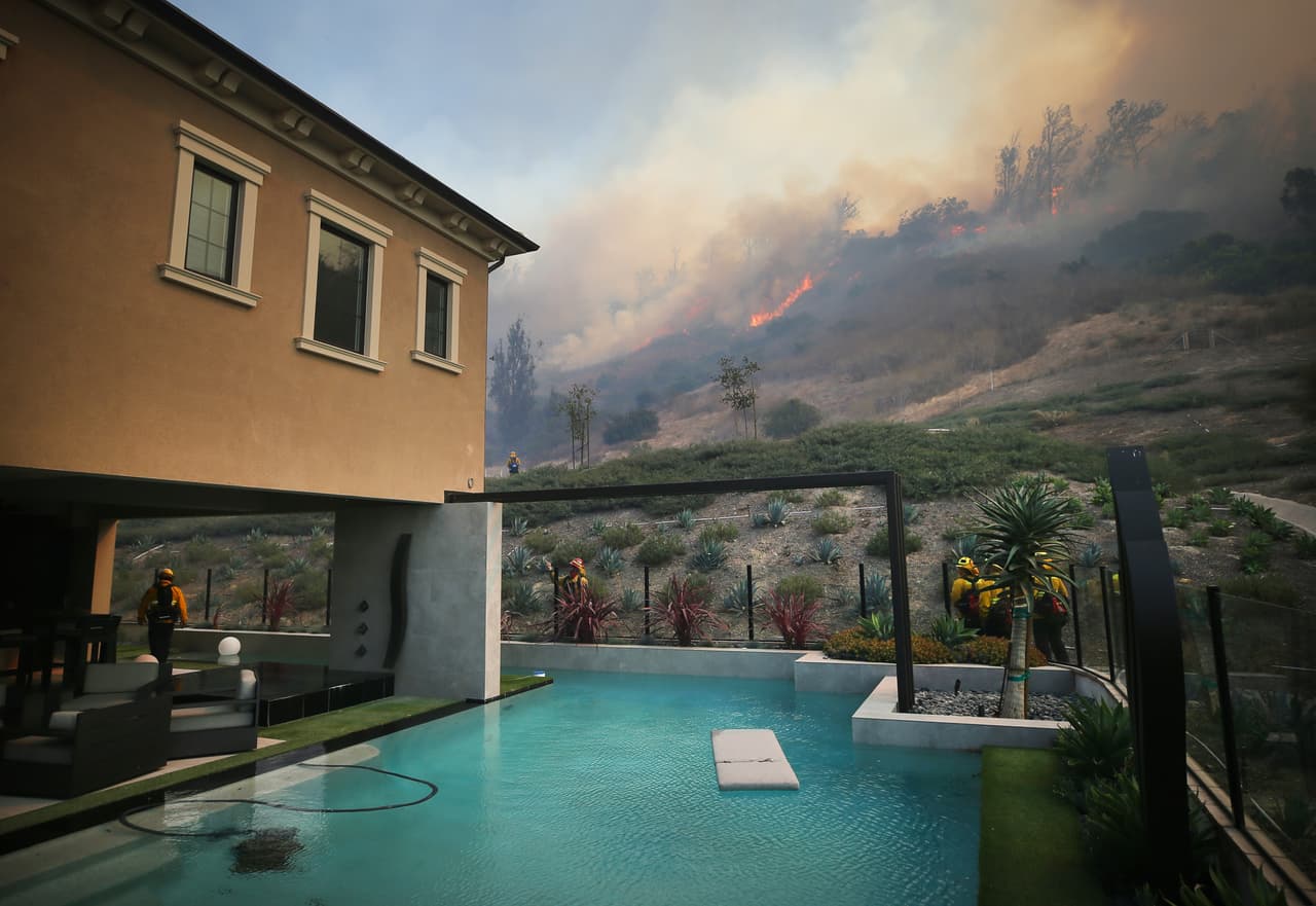 Las ráfagas empujaron las llamas a lo largo de las crestas de matorrales en Silverado Canyon y cerca de las casas en la extensa ciudad de Irvine, hogar de unos 280.000 residentes de los cuales 70,000 fueron evacuados.