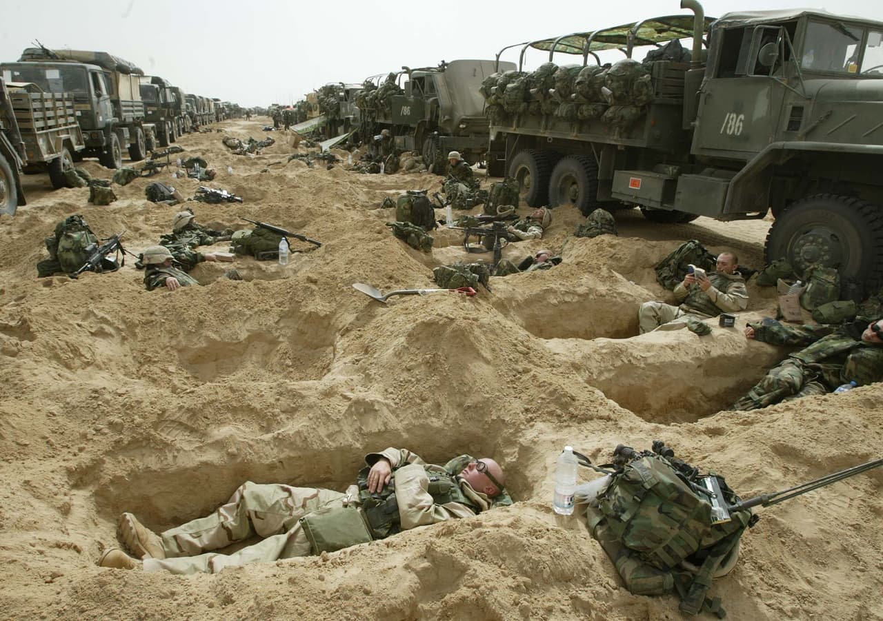 Soldados estadounidenses descansan en el desierto en su camino desde Kuwait hacia la capital de Irak.