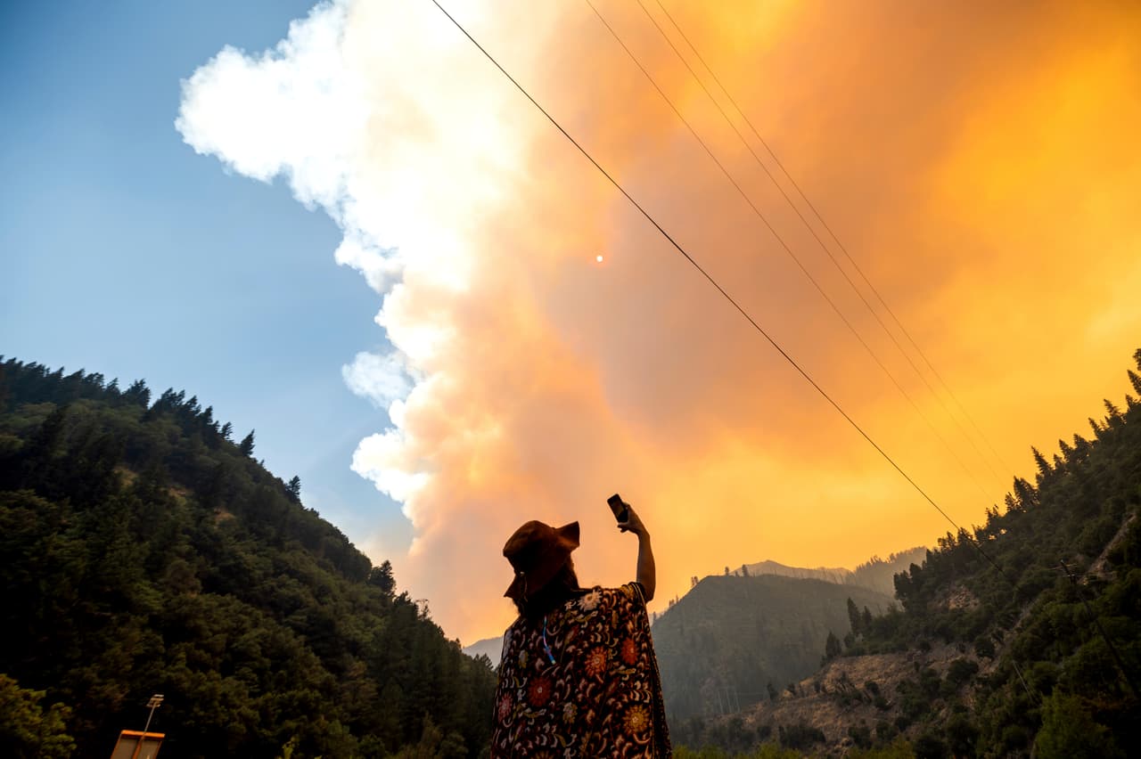 Jessica Bell toma un video mientras el Dixie Fire arde a lo largo de la autopista 70 en el Bosque Nacional Plumas, California.