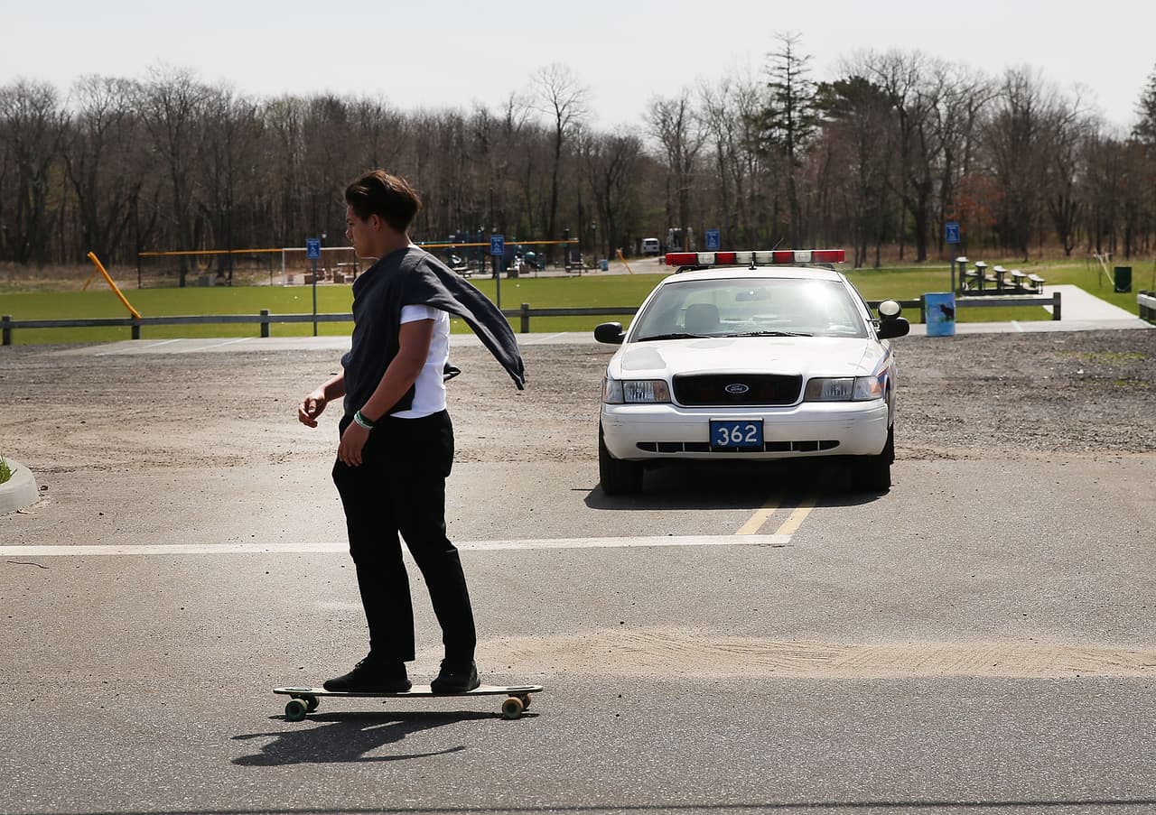 Un adolescente en su patineta frente al parque en Central Islip que fue escenario de la matanza de los cuatro hispanos: Justin Llivicura, Jefferson Villalobos, Michael López y Jorge Tigre. (Spencer Platt/Getty Images)