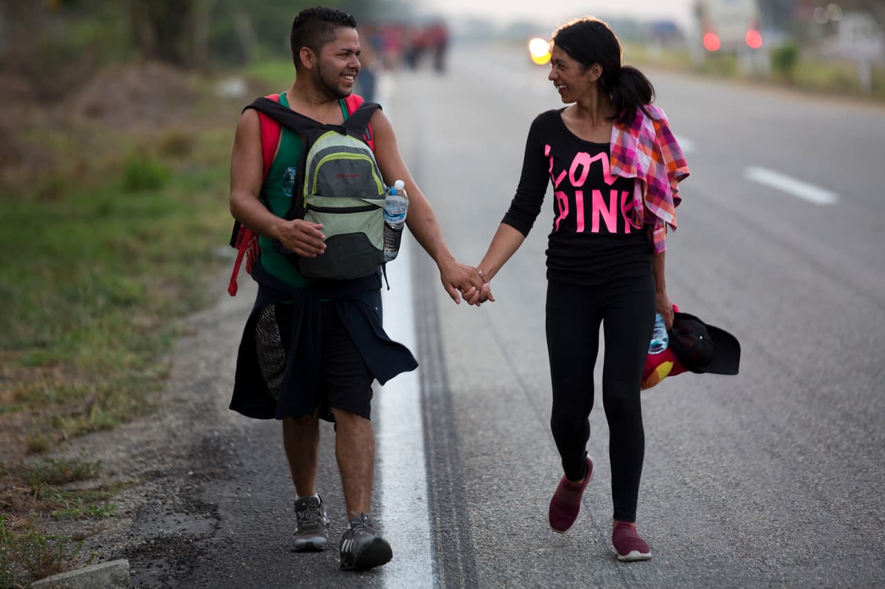 Una pareja de migrantes caminaba este lunes por una carretera de Pijijiapan. 
<b>Esta semana hubo un intento infructuoso de cerrar el paso en esa localidad (Huixtla) a uno de los grupos de migrantes. <a href="https://www.univision.com/noticias/inmigracion/se-acabo-la-solidaridad-con-los-migrantes-el-discurso-xenofobo-se-impone-entre-los-mexicanos">La historia completa de la marcha de estos migrantes aquí.</a></b>