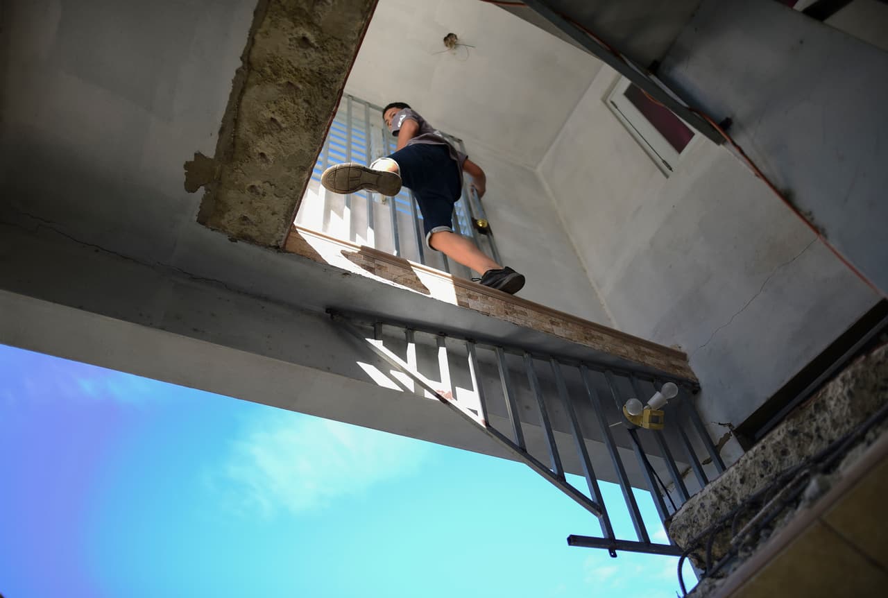 Un joven trepa por una estructura dañada por el terremoto en Guánica.