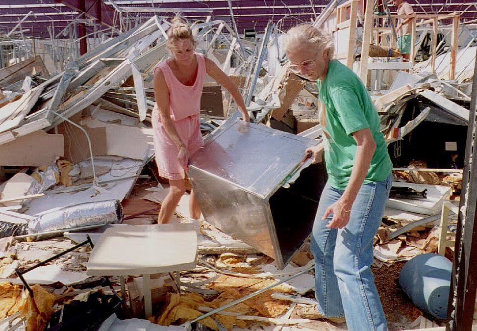 Susanne Miller (R) and Cheryl Winchester of Homestead clear the rubble from their pet supply store in Homestead, Florida 25 August 1992 as Floridians began cleaning up after Hurricane Andrew.