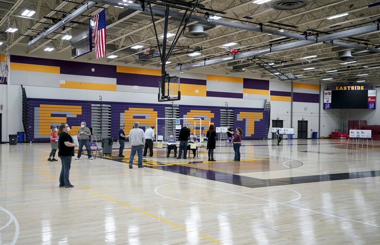 Personas acuden a votar en las elecciones primarias en un gimnasio de la escuela secundaria East, el martes 7 de abril de 2020 en Madison, Wisconsin (Steve Apps/Wisconsin State Journal vía AP)