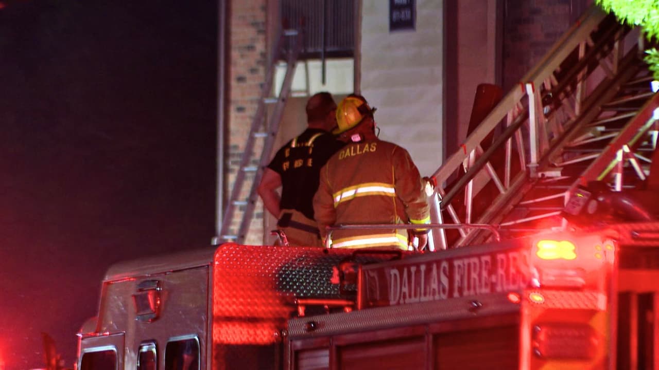 Poco después de las 4 a.m. de este martes, 
<b>un incendio sorprendió a los residentes de un complejo de apartamentos</b> ubicado en el 
<a href="https://maps.app.goo.gl/gcH99M1Xg6u6HoqQ7" target="_blank">1615 de John West Road</a>. Al llegar, los equipos de Dallas Fire Rescue encontraron 
<b>llamas saliendo del techo de un edificio de tres pisos.</b> El panorama obligó a cambiar la estrategia de inmediato: 
<b>el combate al fuego pasó a ser totalmente defensivo.</b>