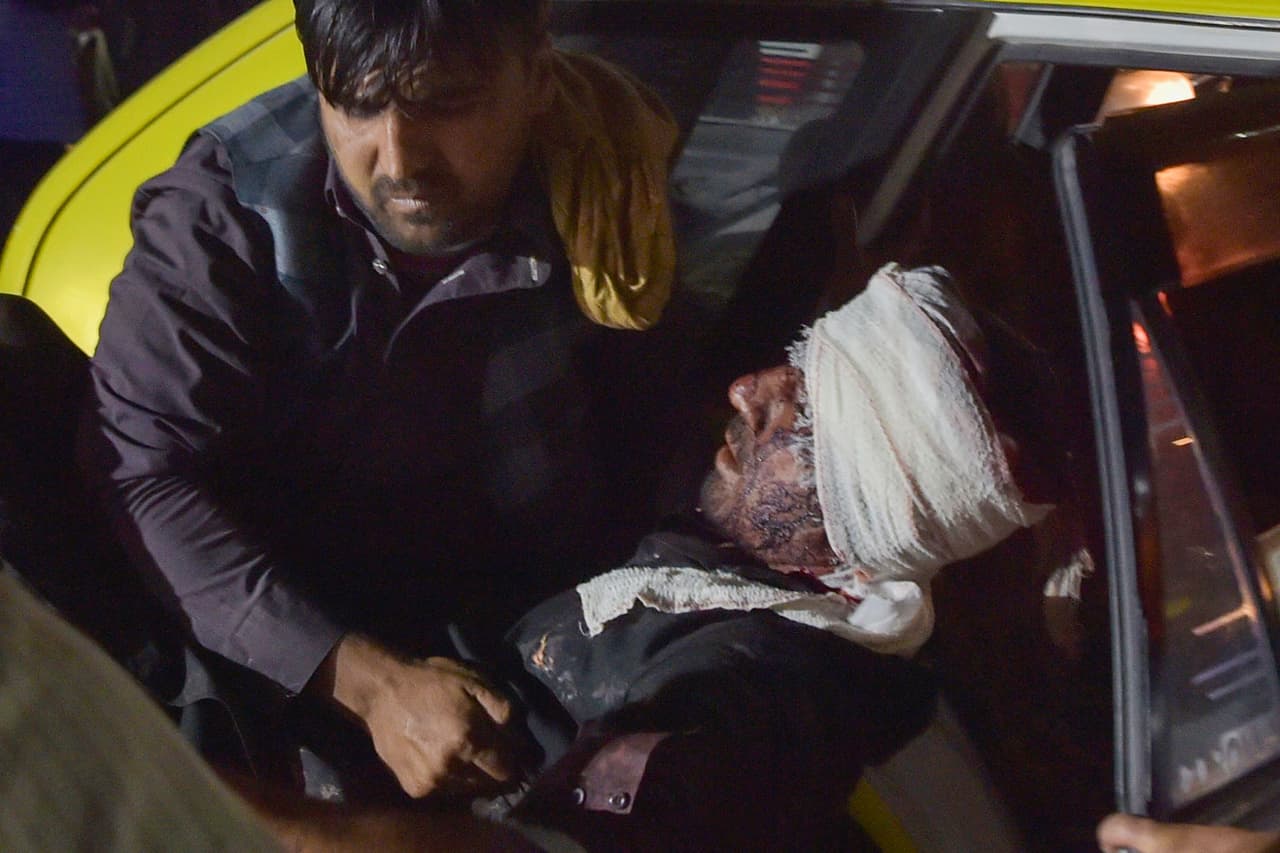 Personal de emergencia asiste a un hombre herido dentro de un auto luego de los ataques. Las explosiones se produjeron pocas horas después de que funcionarios occidentales dijeron que tenían iinformación de inteligencia de que se planeaban atentados suicidas en el área del aeropuerto.