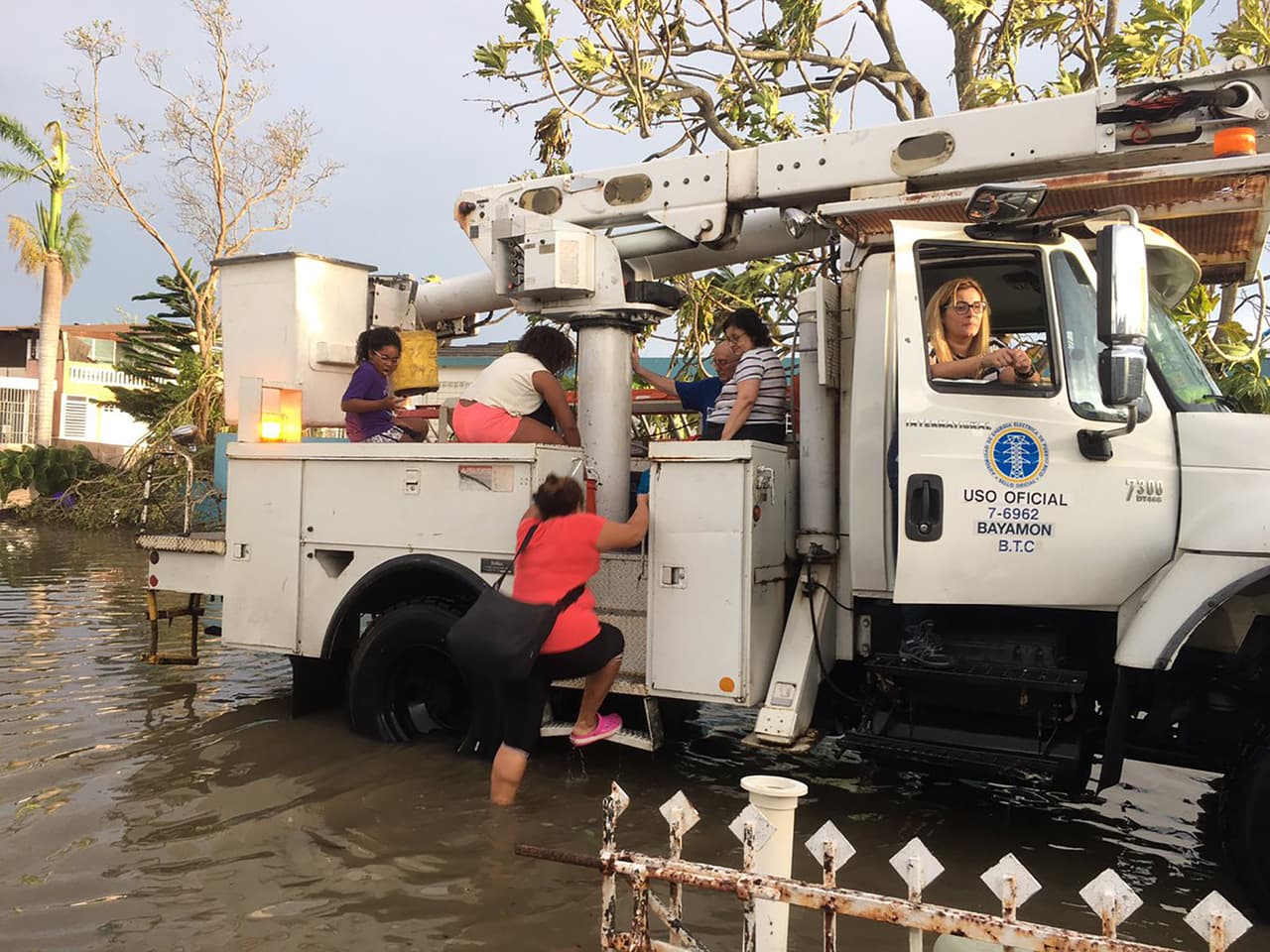Trabajadores de la compañía eléctrica rescatan a personas de la inundación en Levittown. Las autoridades informaron que toda la isla
<b> se quedó 100% sin electricidad. </b>