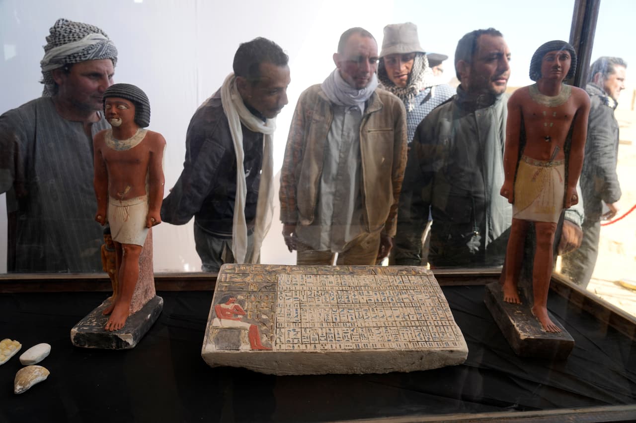 Un grupo de arqueólogos observa algunos de los objetos recuperados, que se calcula podrían tener más de 4,000 años de antigüedad. Los artefactos, desenterrados durante una excavación que duró un año, se encontraron debajo de un antiguo recinto de piedra cerca de las pirámides de Saqqara, y datan aproximadamente desde el 2500 a. C. hasta el 2100 a. C., informó el equipo.