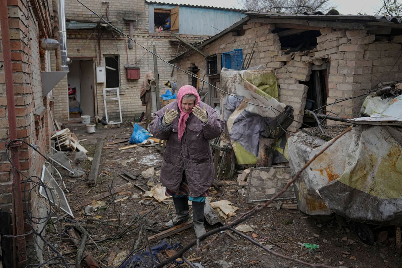 Una mujer recorre el exterior de su residencia dañada en un ataque aéreo ruso en Gorenka, a las afueras de Kiev, el 2 de marzo. La agencia de refugiados de Naciones Unidas dijo que un millón de personas han abandonado Ucrania desde que las fuerzas rusas invadieron la semana pasada. 
<br>