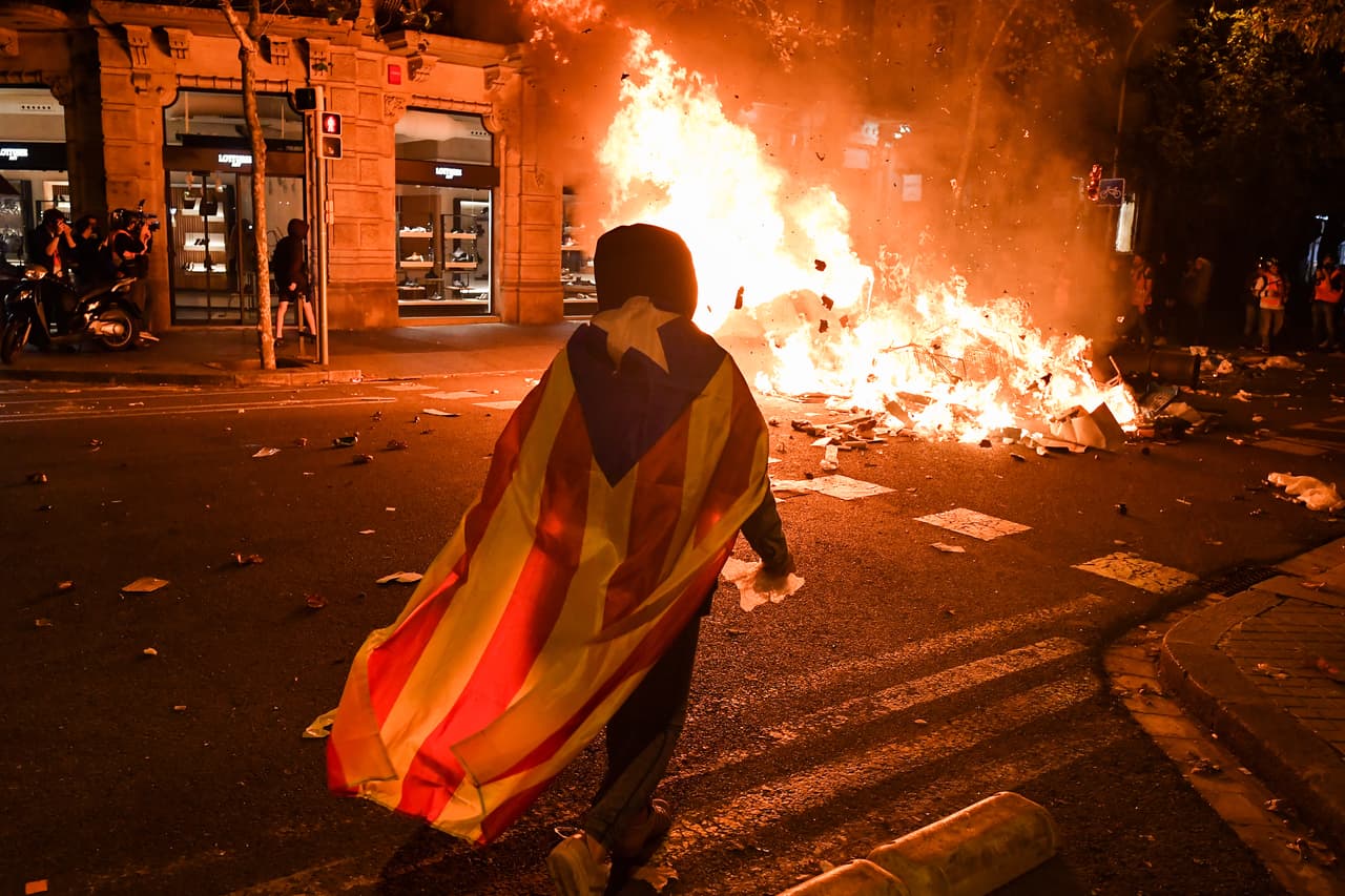 <b>El independentismo enciende Cataluña. </b>Un manifestante frente a una pila de escombros quemados en Barcelona el 17 de octubre de 2019. Las condenas de hasta 13 años de cárcel a nueve líderes independentistas de Cataluña 
<a href="https://www.univision.com/noticias/mundo/que-esta-pasando-en-la-turistica-barcelona-oleada-de-protestas-masivas-y-violencia-en-aumento">desencadenaron las protestas y un caos en las calles de esta y otras ciudades</a>, donde las reivindicaciones pacíficas de decenas de miles acabaron en manos de unos cientos de violentos.