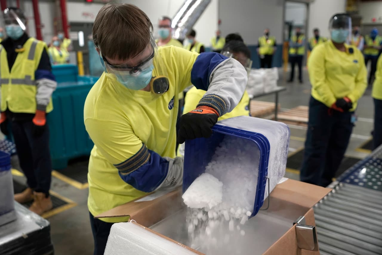 Este trabajador vierte hielo seco a una de las cajas que almacenarán las vacunas de Pfizer y BioNtech contra el covid-19, la primera en ser autorizada para su uso de emergencia en el país y que conlleva estrictas medidas de refrigeración.