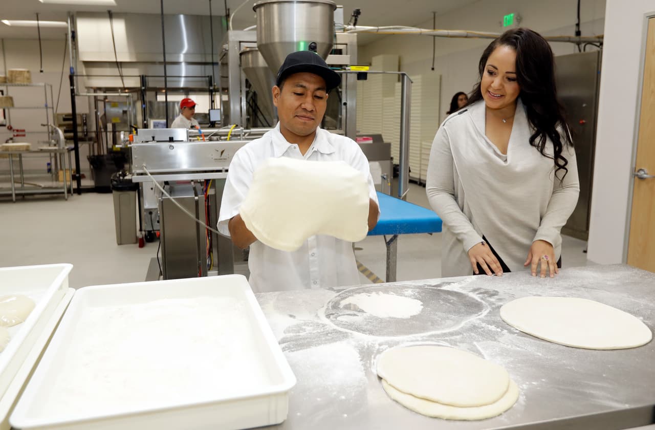 La mano de obra humana continúa siendo un factor importante, ya que hay ciertas tareas que las máquinas no pueden completar, pero los robots se encargan de untar la salsa sobre la masa y poner las pizzas dentro del horno.