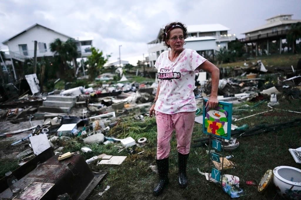 Jewell Baggett, de pie junto a una decoración navideña que recuperó de entre los restos de la casa de su madre, mientras busca otras pertenencias en la casa rodante que su abuelo adquirió en 1973 y en la que se hicieron varias ampliaciones a lo largo de las décadas, en Horseshoe Beach, Florida, tras el paso del huracán Idalia, el 30 de agosto de 2023.
