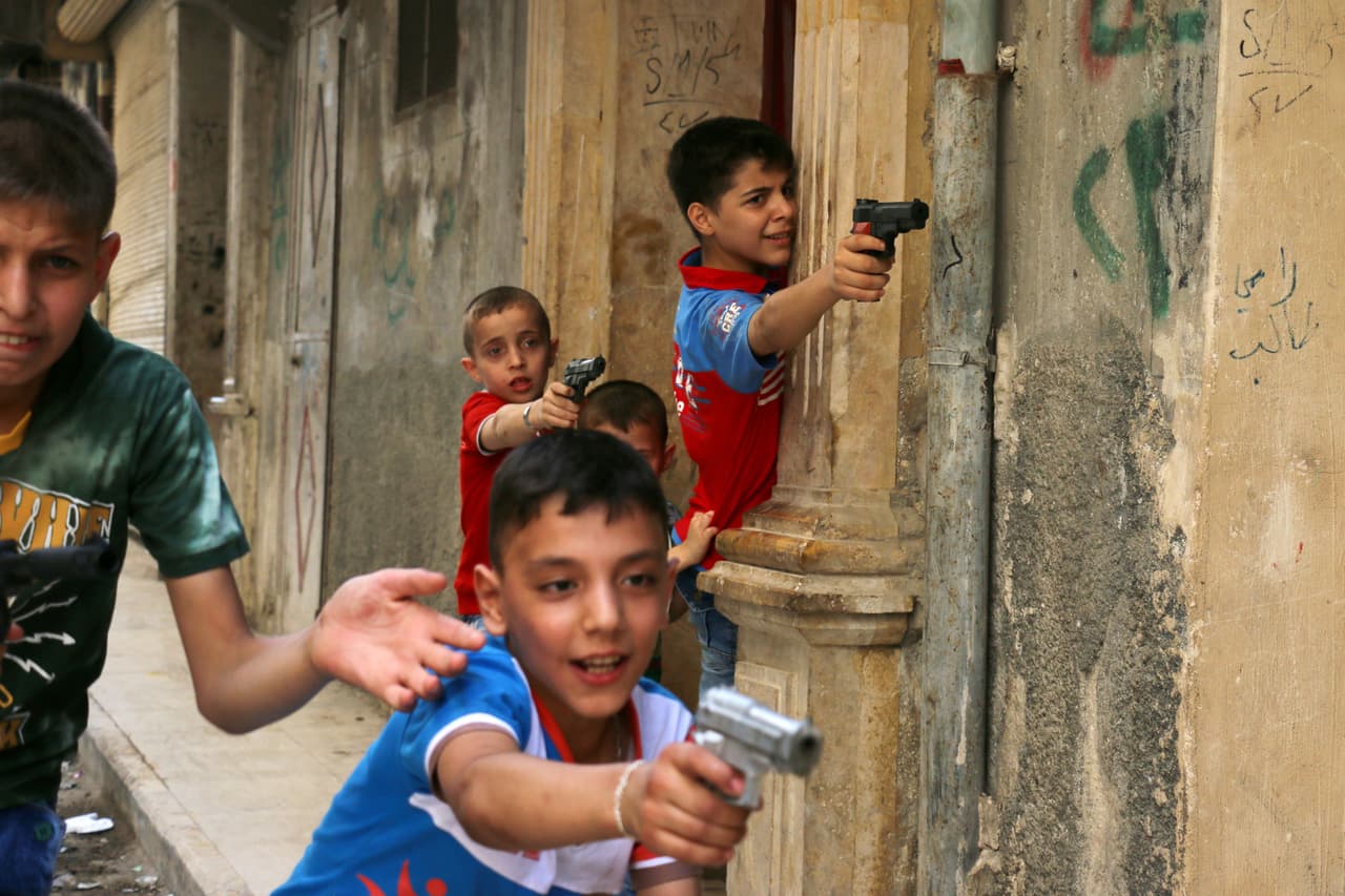 Un grupo de niños sirios juega en la calle con armas de juguete en una zona controlada por los rebeldes en el norte de Alepo, el 7 de junio de 2016. Amnistía Internacional advierte que tanto Rusia como Estados Unidos han hecho ataques aéreos contra los rebeldes en los que han sido afectado miles de civiles.