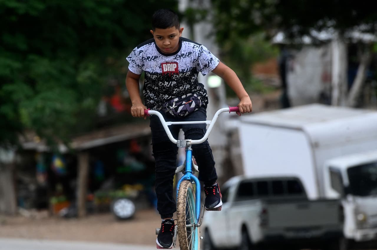 Eduardo Espinal va en bicicleta a su barbería. 
<br>
<br>Los 
<a href="https://www.univision.com/temas/pobreza">bajos ingresos</a>, la falta de oportunidades de trabajo y la 
<a href="https://www.univision.com/temas/actividad-de-pandillas">violencia de pandilleros y narcotraficantes</a> en Honduras obliga a cerca de 800 nacionales a emigrar cada día hacia Estados Unidos, donde viven más de un millón de hondureños, la mayoría sin permiso de residencia y de trabajo.
<br>
