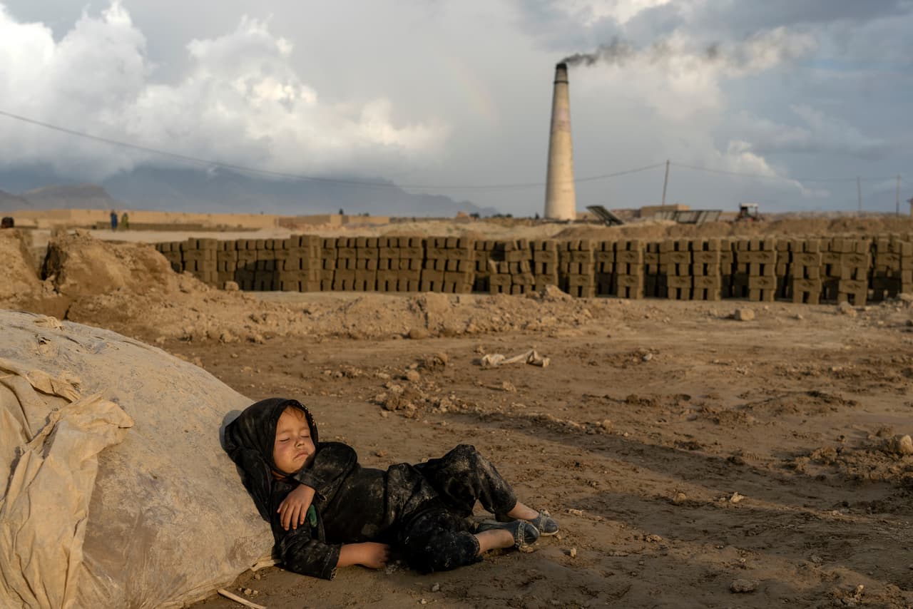 En la foto, una niñita de 4 años duerme después de laborar fabricando ladrillos.