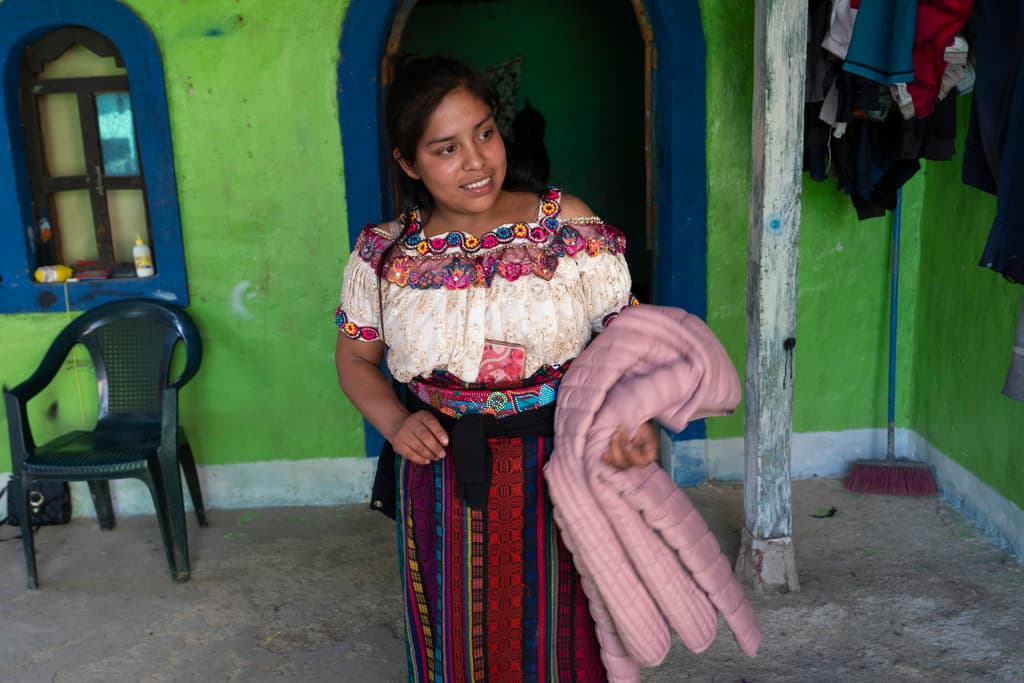 Glendy Aracely Ramirez muestra el abrigo que se compró para su viaje con destino a Estados Unidos.