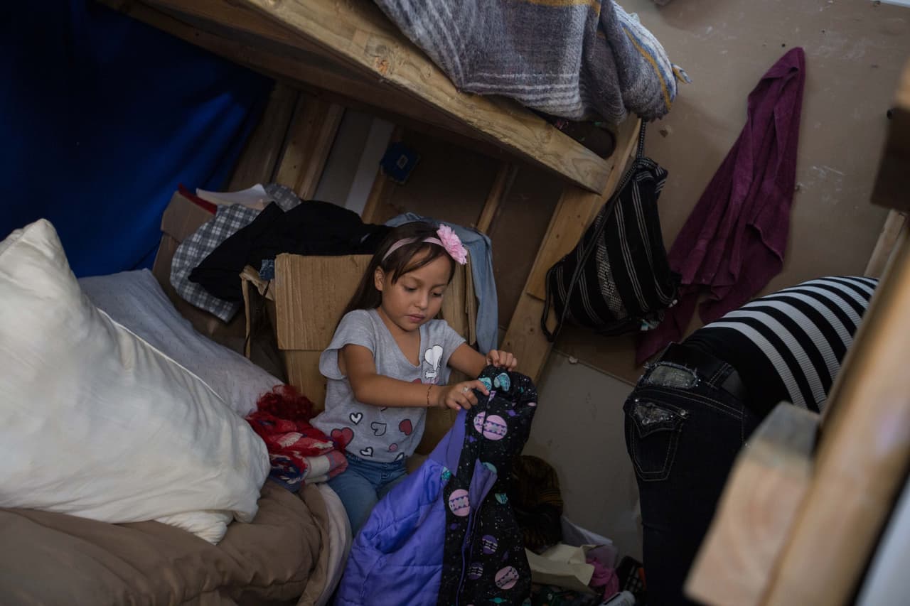 Atziry, de 7 años, repitió tanto su deseo de volver a Guatemala que a la madre no le quedó otra opción. Una noche le dijo: 
<b>"Mami, no quiero estar aquí, vamos a regresarnos",</b> y el llanto de la niña la llevó a tomar la decisión porque, explica, no quiere que sus hijos sufran más. En la imagen, la niña prepara su maleta y su abrigo poco antes de partir del albergue Ágape, en el que durmieron durante cuatro meses.