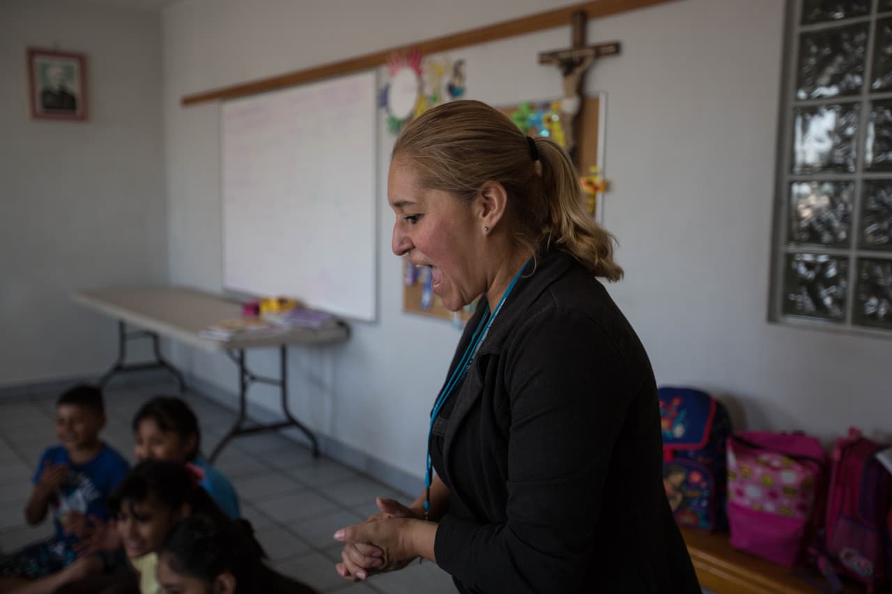 En el albergue Madre Asunta, en Tijuana, Rosario Castro es la maestra. Dispusieron un salón en el que juegan y hacen tareas como una forma de ayudar a los menores a pasar las largas horas y días de espera mientras le llega el turno a sus familias de cruzar a Estados Unidos. 
<b>"Me han tocado niños felices, pero también tristes", </b>dice Castro. En muchos casos, cuenta que los niños no entienden por qué están en México: "No es una preocupación para ellos, pero para la mamá sí. Cuando los retornan lo ven como parte del proceso desde que salieron de sus casas". Explica que son pocos los que se quieren regresar a sus países y la principal razón es la familia que dejaron.