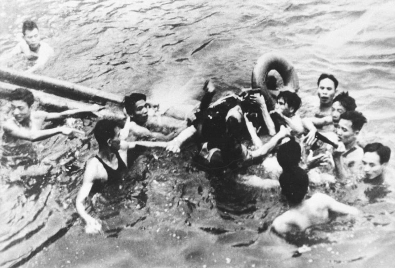 El avión A-4E Skyhawk que pilotaba McCain fue derribado por un misil. En la imagen, tomada en Hanoi el 26 de octubre de 1967, John McCain es sacado del agua por soldados y civiles de Vietnam del Norte. Se rompió ambos brazos y la rodilla derecha. Perdió la conciencia pero la recuperó al chocar contra el agua.