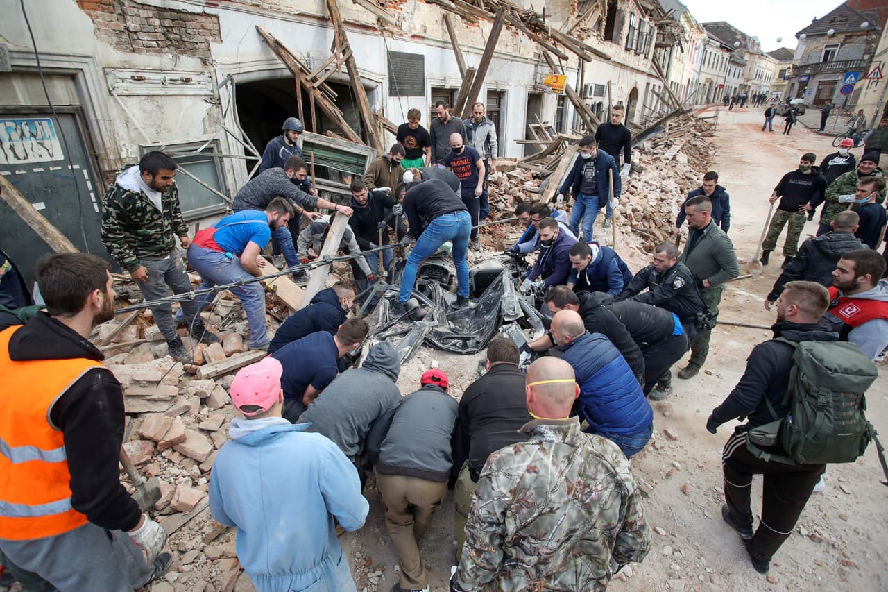 Ciudadanos ayudan a limpiar los escombros junto a los edificios dañados, uniéndose a los equipos de rescate y el ejército para buscar a los residentes atrapados.