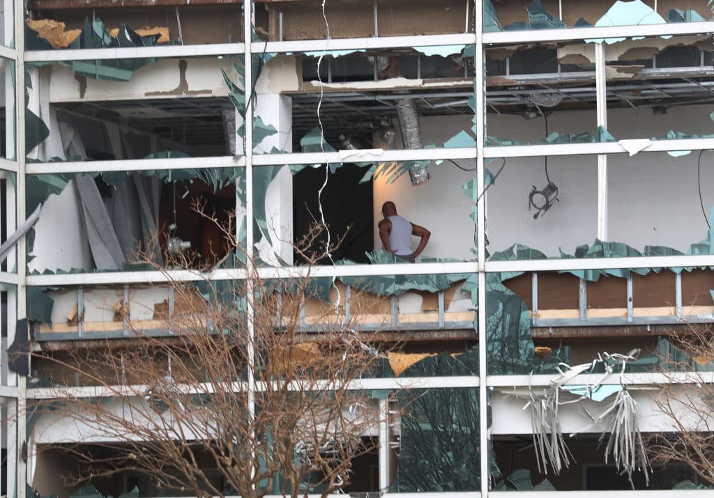Una persona puede verse dentro del edificio, con toda la cristalería destruida y otros daños.
